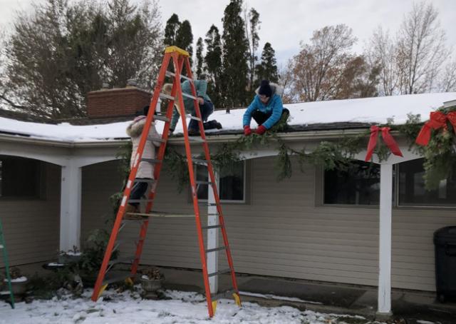Kate Timmerman, Emma Arnold, Brynn Staab work together to hang up roping at the Lutheran Home