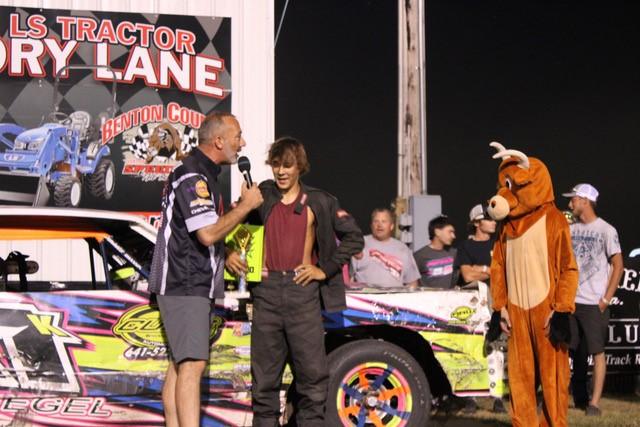 Benton County Speedway mascot Brisket looks on as IMCA Sunoco Hobby Stock driver Briar Kriegel celebrates his career first feature win Sunday night at The Bullring. (Madison Adams photo)