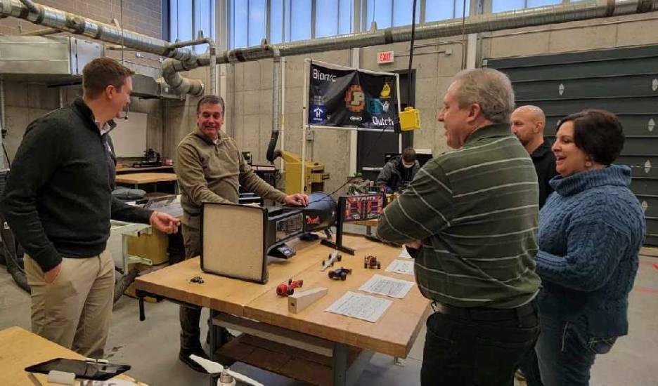 Explaining how students study aerodynamics with model cars the students make from a block of wood is Industrial Technology Instructor Brent Ewell (second from left). Also in photo from left is Vinton Shellsburg Superintendent Kyle Koeppen, Mr. Ewell, Rep