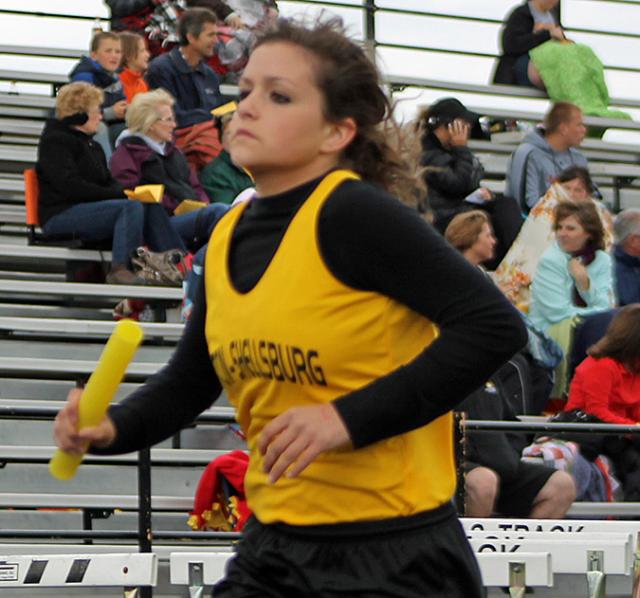 Chloe Osborne carries the baton for the first-place 8th grade Vikette 4 x 800 team.