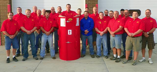 Jason Laton (in the Res-Q-Tube) and other Vinton firefighers pose with Okee Walker of CR Conveying.