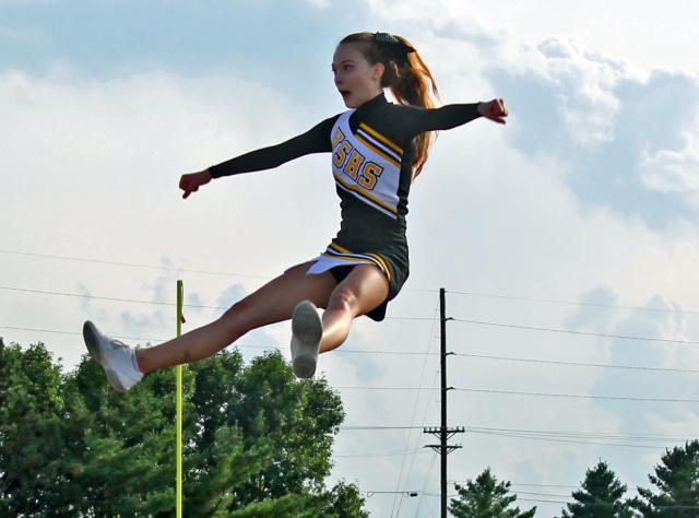 VS football cheerleader Kayla Udell soars high above her peers during a stunt on Friday.