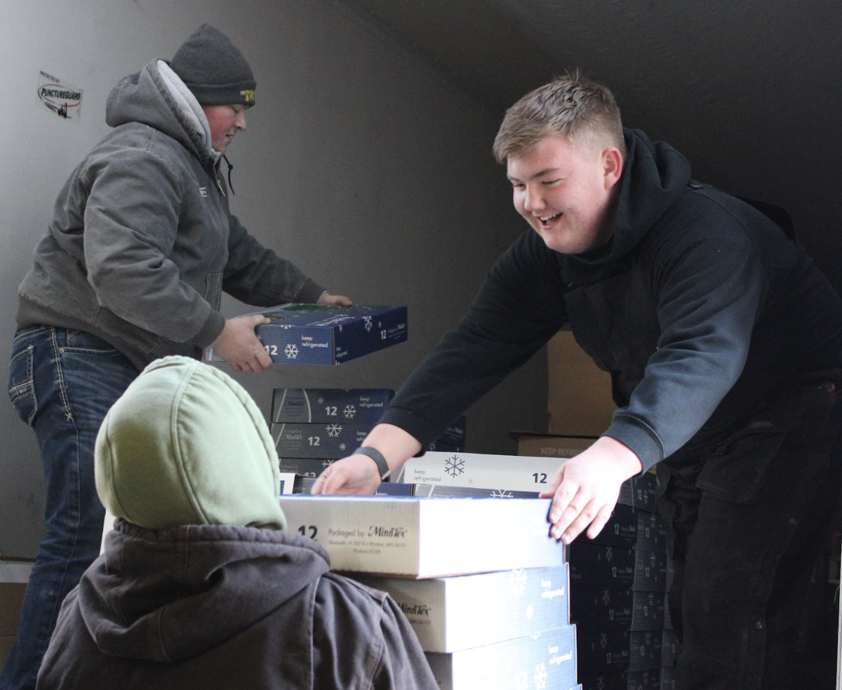 Members Will McKenna and Andrew Pingenot working on unpacking fruit deliveries