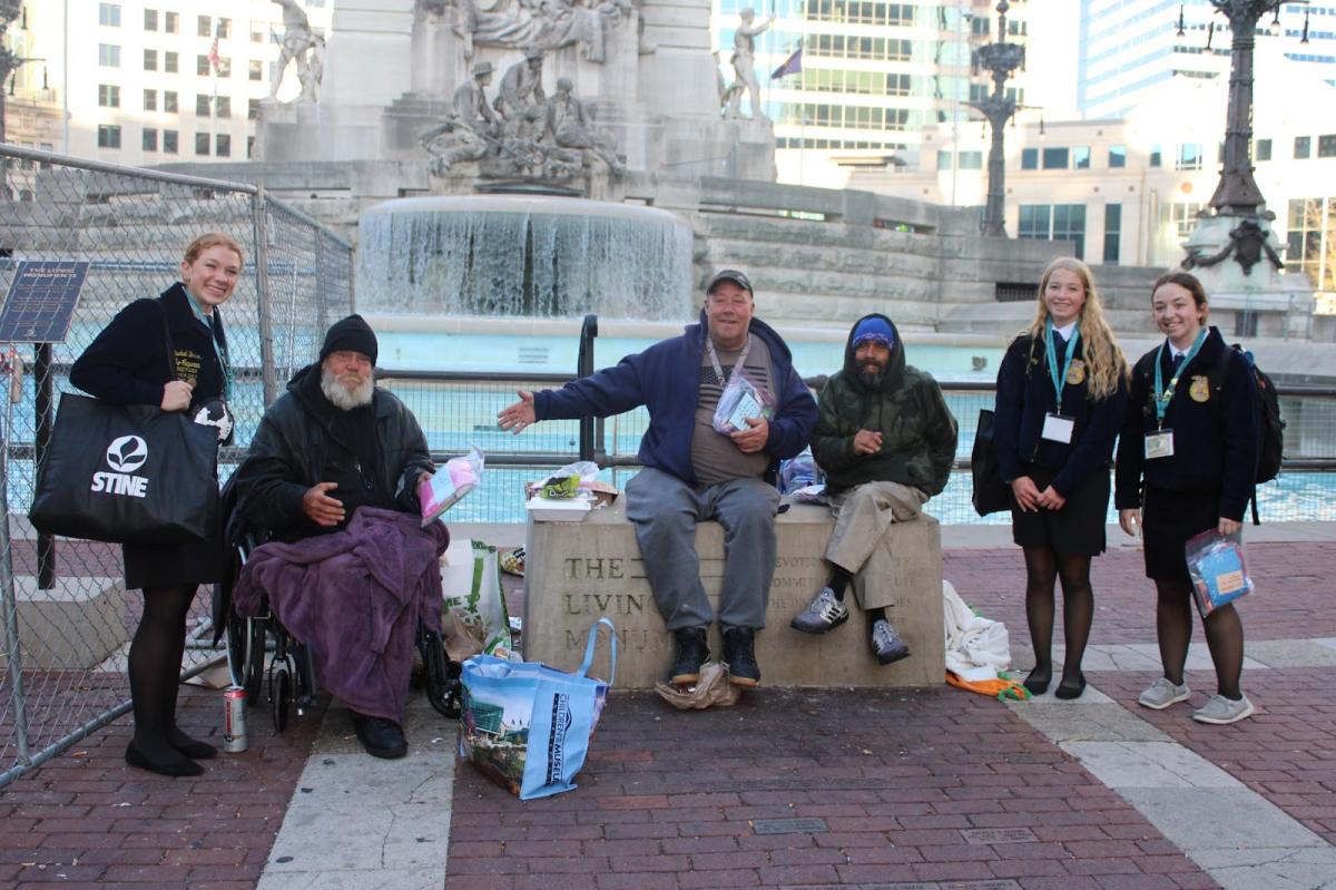  Members Izzie Birker, Alana Fleming, and Megan Schlitter handing out blessing bags to people in need. 