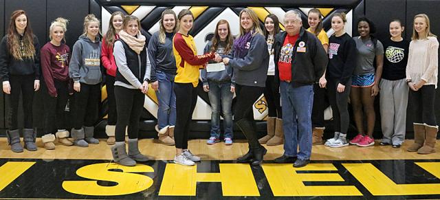Vikette senior Maci Griffith and the Vikettes present a check to Toni Parizek for the Veterans Fund.
