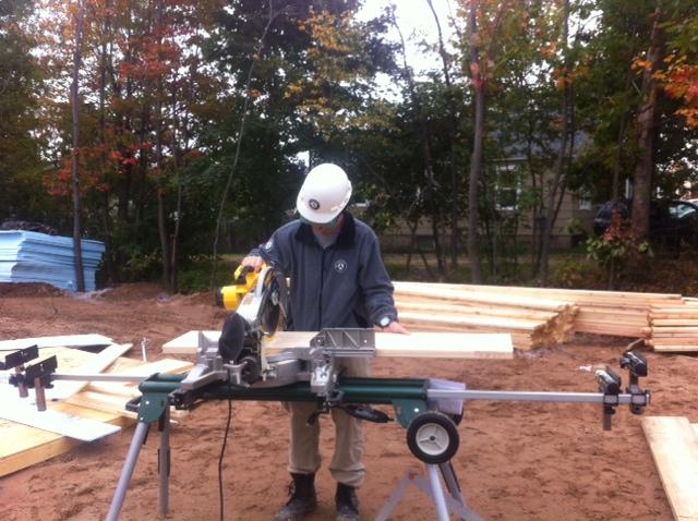 Oak 5 teammate cuts pieces of wood to use as studs in the home.