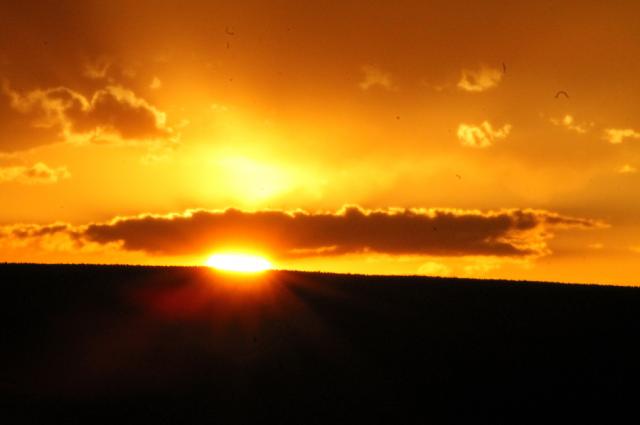 The sun sets through a break in the clouds after the storm Monday.