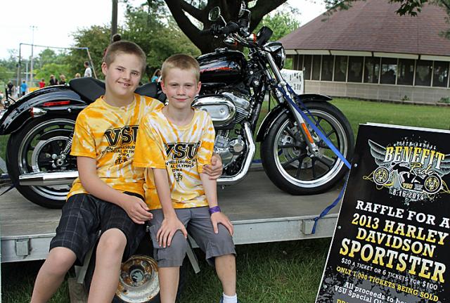 Zach Kramer and Mike Malmgren pose with the Harley offered in the local Special Olympics raffle.